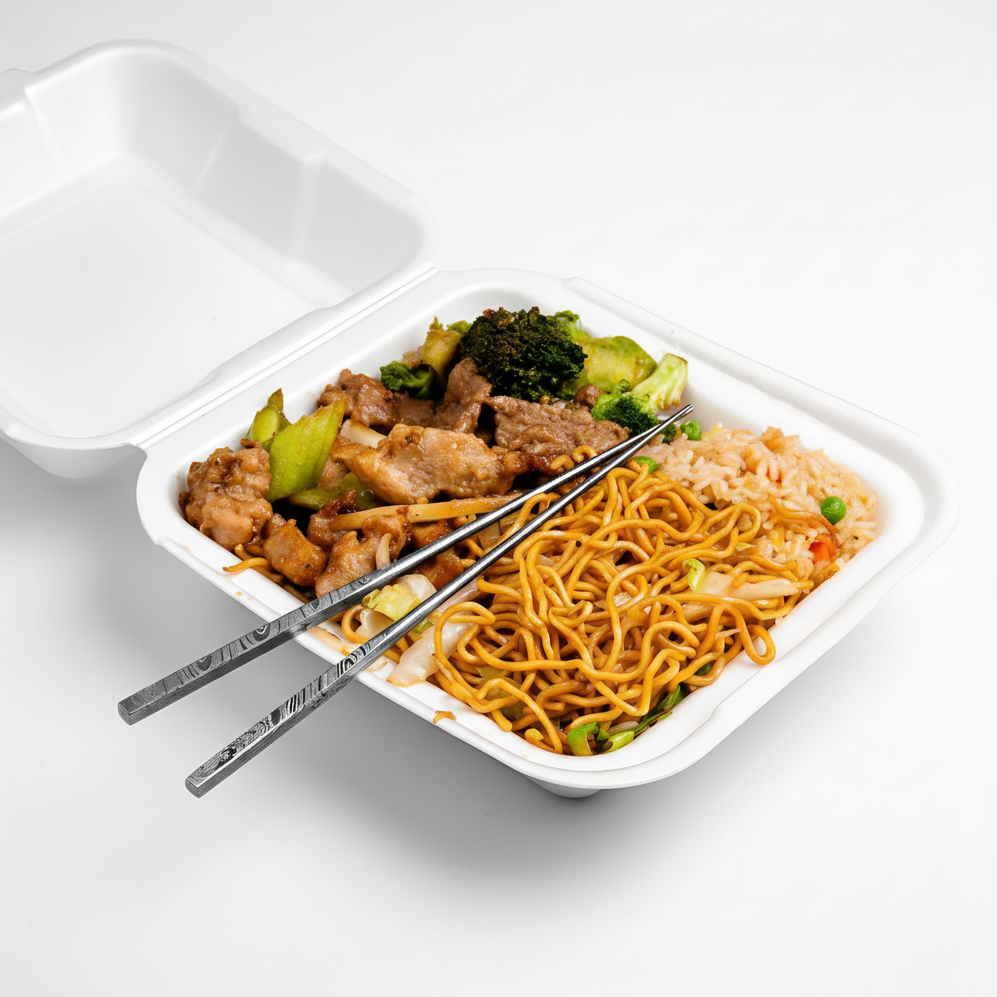 Takeout container with Chinese food including noodles and vegetables on a white background