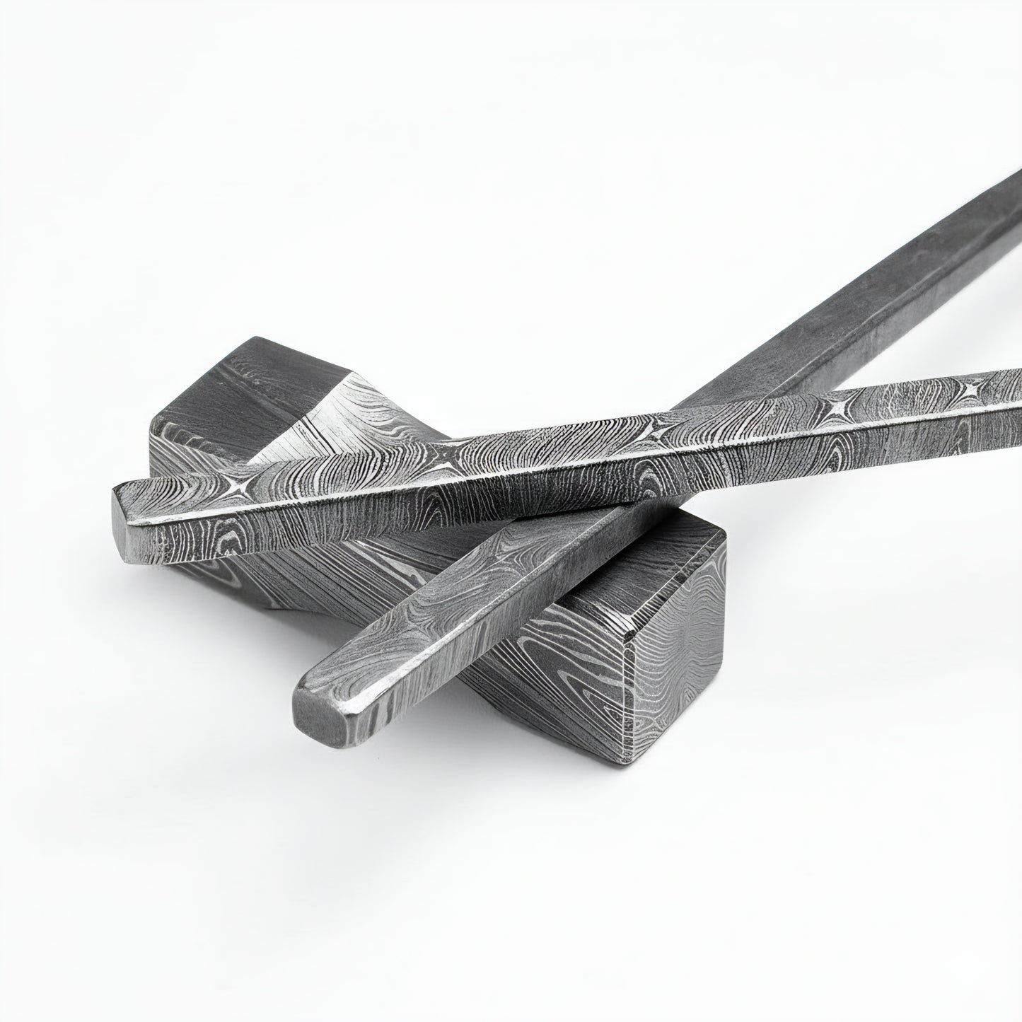 Two metal tools with intricate patterns on a white background