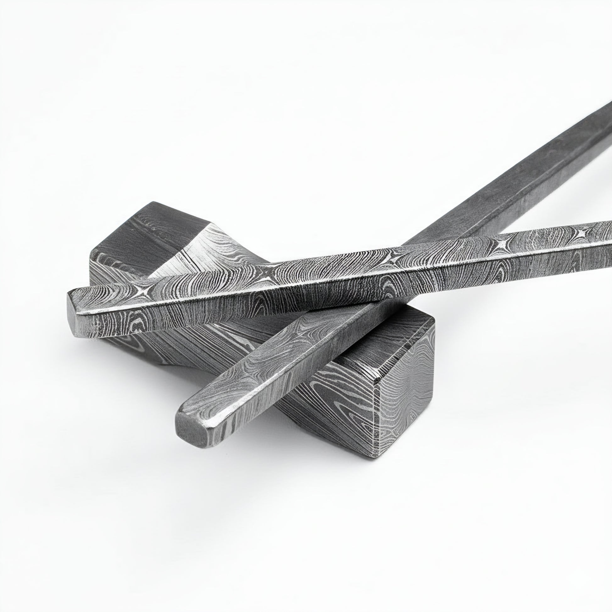 Two metal tools with intricate patterns on a white background