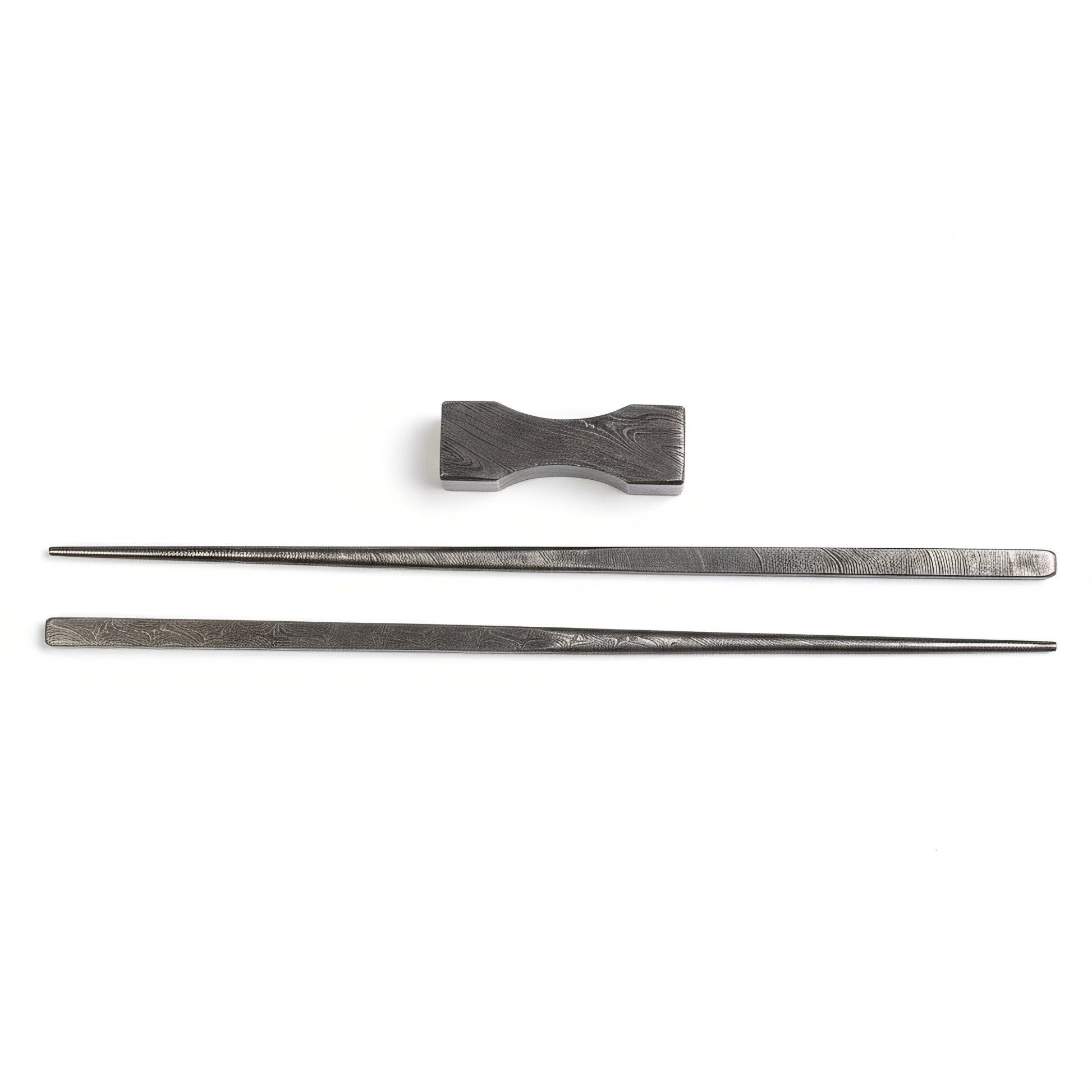 Set of black metal chopsticks with a matching holder on a white background