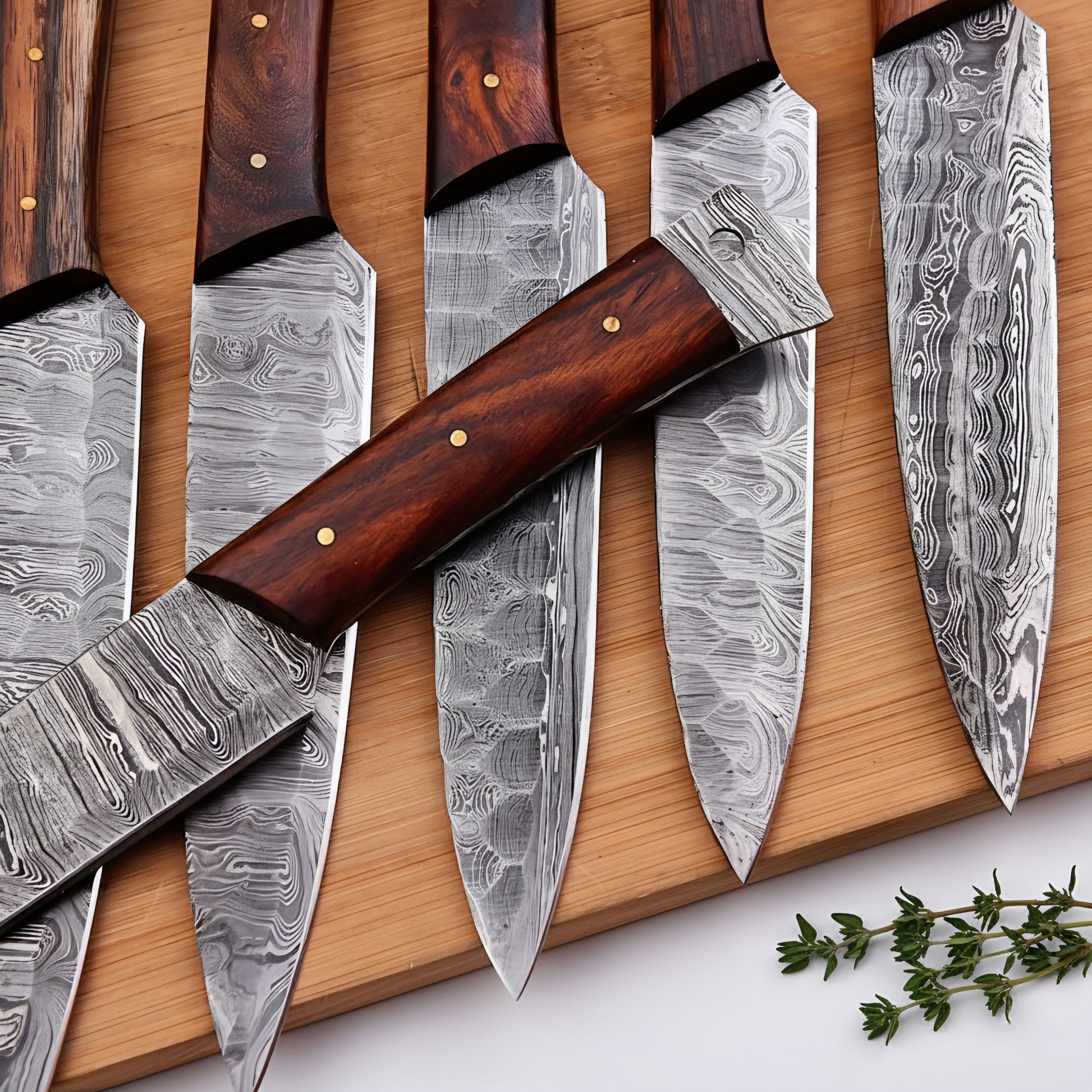 Set of knives with wooden handles and damascus steel blades on a wooden board.