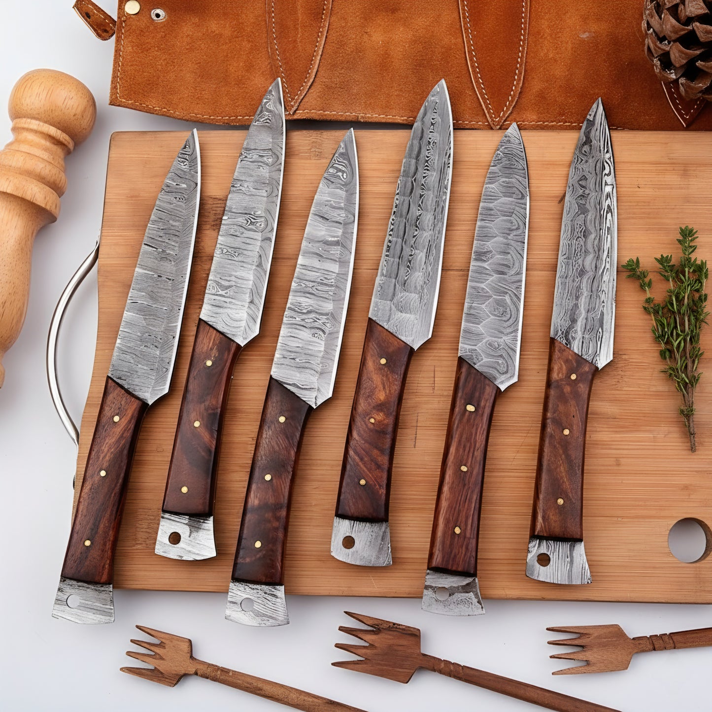 Set of six Damascus steel knives with wooden handles on a wooden cutting board.
