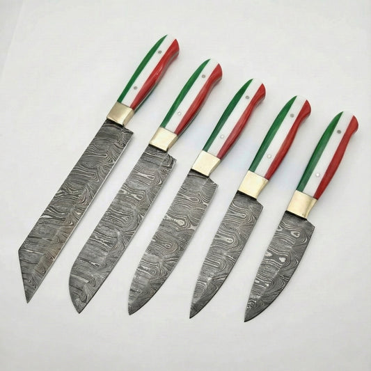 A set of five custom kitchen knives arranged diagonally on a white background. Each knife features a Damascus steel blade with a swirling, wavy pattern and a brass bolster. The handles are uniform across the set, designed with vertical stripes of green, white, and red to represent the Italian flag. The blades vary in shape and size, including a large cleaver-style blade, a chef's knife, and smaller utility or paring knives.