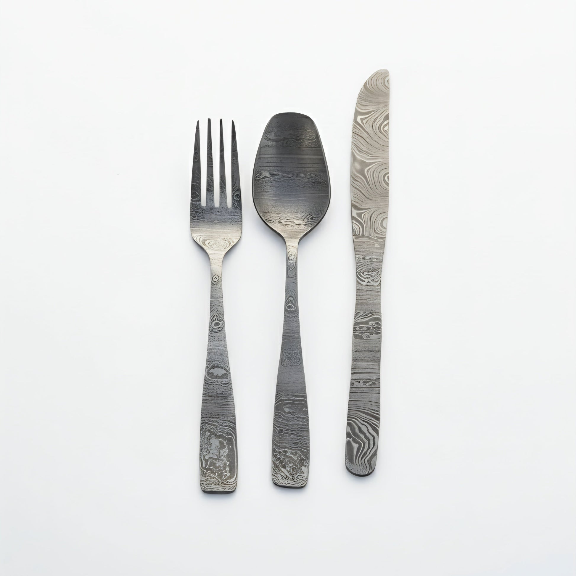 Set of silver cutlery with unique pattern on a white background Damascus cutlery set