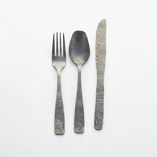 Set of silver cutlery with unique pattern on a white background Damascus cutlery set
