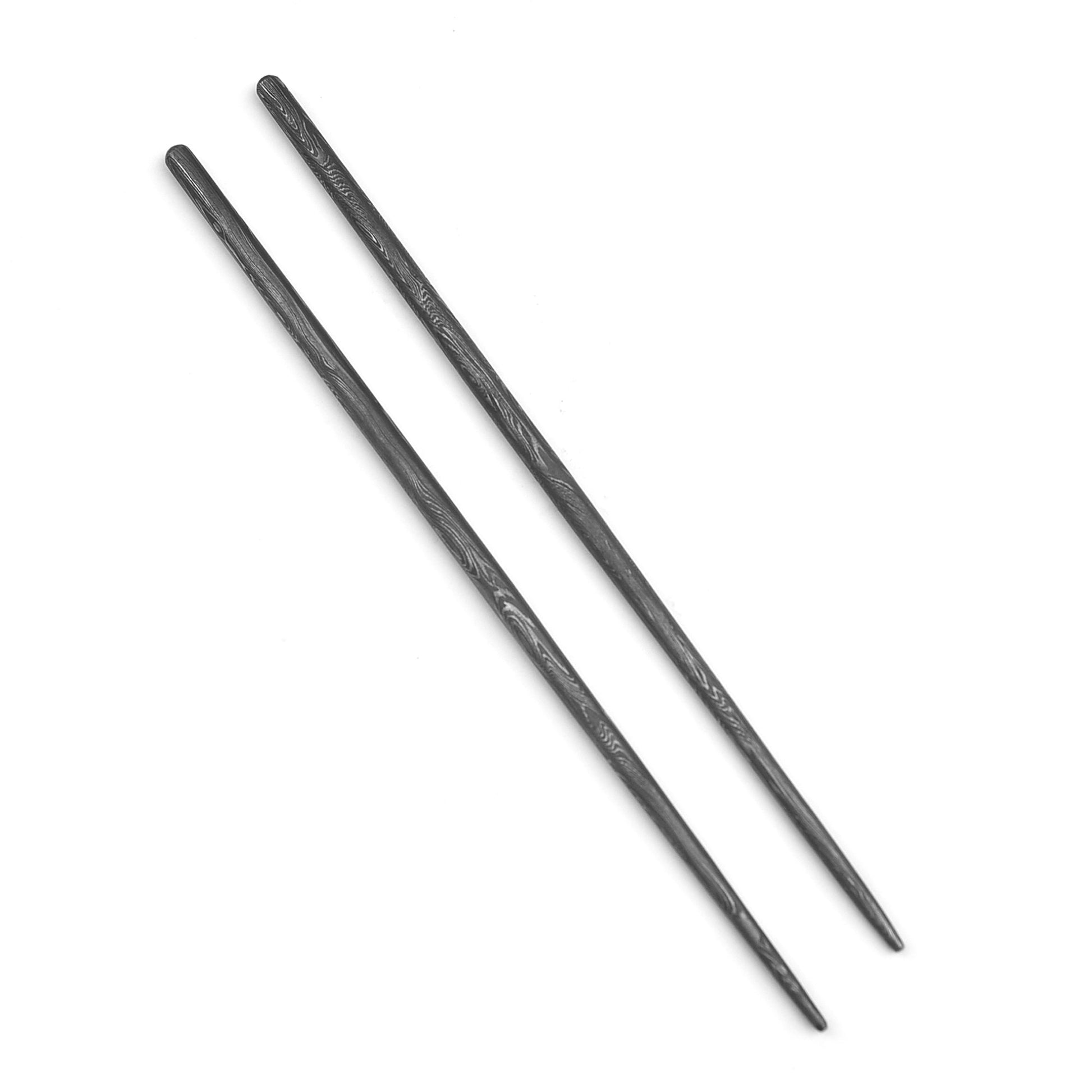 Two black chopsticks on a white background